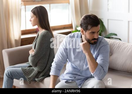 Arrabbiato coppia giovane sedersi sul lettino di evitare di parlare dopo la lotta Foto Stock