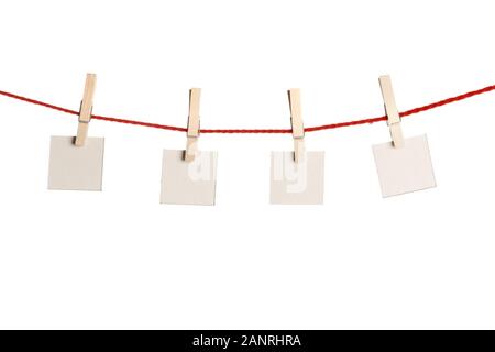 Set di quattro rosso vuoto note di carta tenuto su una stringa con clothespins isolati su sfondo bianco Foto Stock