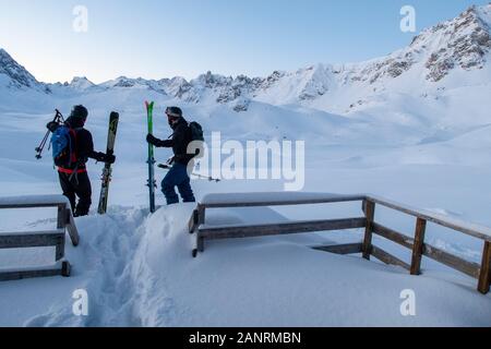 Due gli sciatori lasciare il rifugio des lacs Merlet nelle prime ore del mattino dopo la nevicata vicino a Courchevel nelle Alpi francesi. Rifugio di montagna. Foto Stock