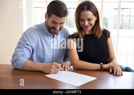 Felice coppia sposata firma contratto, rendendo trattativa legale Foto Stock