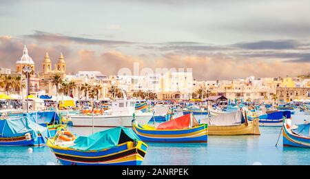 Fisherman Port villaggio di Marsaxlokk Malta. Mediterraneo tradizionale retro barche colorate luzzu d'estate Foto Stock