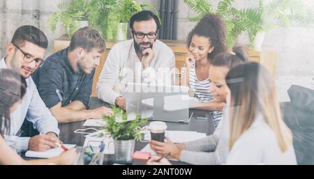 I giovani uomini di affari riunione in ufficio e discutendo insieme un nuovo progetto di avvio. Foto Stock