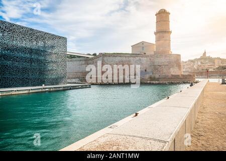 Fort Saint-Jean proteggendo l'ingresso del porto vecchio con la torre di Fanal e luce drammatica a Marsiglia Francia Foto Stock