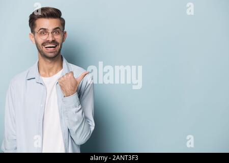 Felice sorpresa giovane uomo che mostra copia vuota dello spazio. Foto Stock