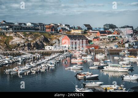 Vista panoramica del porto e del porto di Ilulissat, Groenlandia occidentale. Piccolo locale fisher barche con edifici in background. Blu cielo con sunny weathe Foto Stock