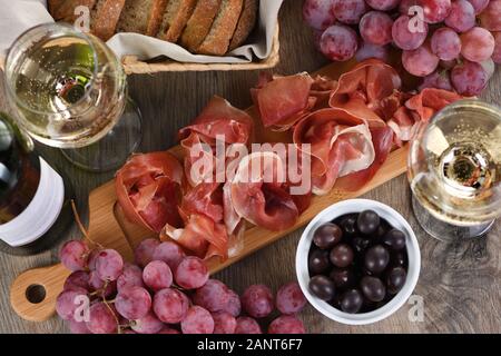 Antipasto. Set vino snack sun-prosciutto jamon con uve e olive Foto Stock