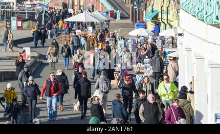 Brighton Regno Unito 19 Gennaio 2020 - folla godetevi il sole ma il freddo sul lungomare di Brighton con più sole previsioni per la maggior parte della Gran Bretagna nei prossimi giorni : credito Simon Dack / Alamy Live News Foto Stock