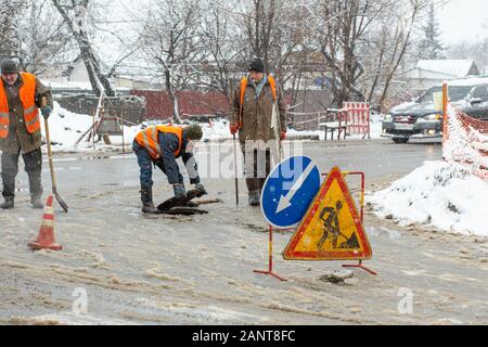 Città del servizio di emergenza di riparazione rottura tubo acqua in inverno. Foto Stock