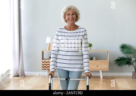 Ritratto sorridente anziani disabili donna in piedi con walker Foto Stock