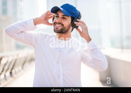 Medio-orientale per adulti giovani indossano kandora passeggiate all'aperto in Dubai - uomo arabo indossando i tradizionali abiti emirates Foto Stock