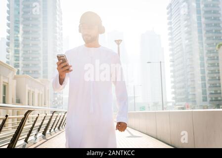 Medio-orientale per adulti giovani indossano kandora passeggiate all'aperto in Dubai - uomo arabo indossando i tradizionali abiti emirates Foto Stock
