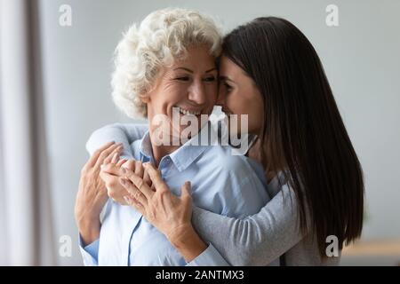Nonna sorridente e nipote abbracciava, godendo di momento di gara Foto Stock