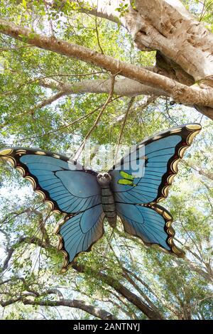 Una scultura di farfalla è appeso a un albero a Giardini Botanici Marie Selby di Sarasota in Florida, Stati Uniti d'America. Foto Stock