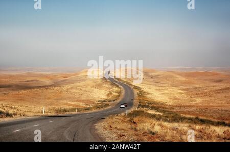 Vetture corsa sulla strada del deserto attraverso la steppa e colline in Kazakistan Foto Stock