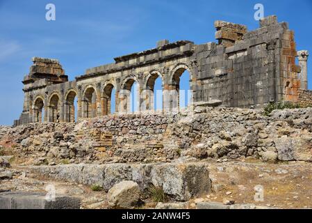 La rovinata Basilica, uno scavo romano nell'antica città berbera di Volubilis, vicino alla città di Meknes, Marocco, Nord Africa. Foto Stock