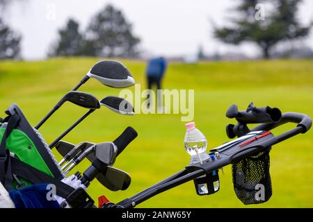 Borsa da golf su trolley con diversi club e una bottiglia di acqua su un carrello su un campo da golf durante una concorrenza di golf Foto Stock