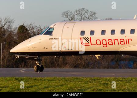 Loganair ERJ-135 Jet Plane chiamato Clan Inglis taxiing per la partenza all'aeroporto di Londra Southend, Essex, Regno Unito. Nel tardo pomeriggio in inverno. Bagliore arancione Foto Stock