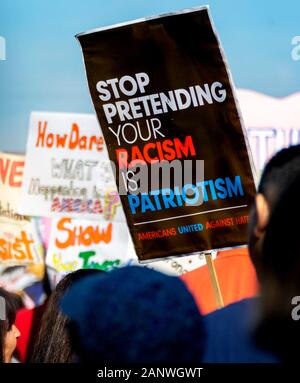 Gruppo di attivisti a OC donna marzo con segni di protesta. Si legge, "smetterla di far finta che il razzismo è il patriottismo. Gli americani uniti contro odio". Foto Stock