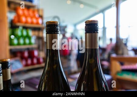 Due bottiglie di vino in alto, con il nero e vite dorata della guarnizione del cappuccio di colore, il collo e le spalle della bottiglia closeup messa a fuoco selettiva, vini shop sfondo Foto Stock