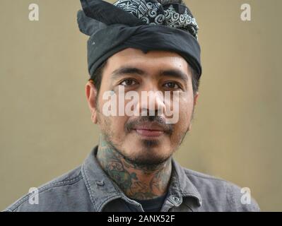Bel tatuaggio balinese con collo tatuato indossa un tradizionale udang e posa per la macchina fotografica. Foto Stock