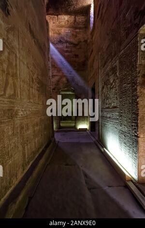 Fascio di luce solare che illumina parzialmente i geroglifici su una delle pareti del Tempio di Hathor nel complesso del Tempio di Dendera Foto Stock