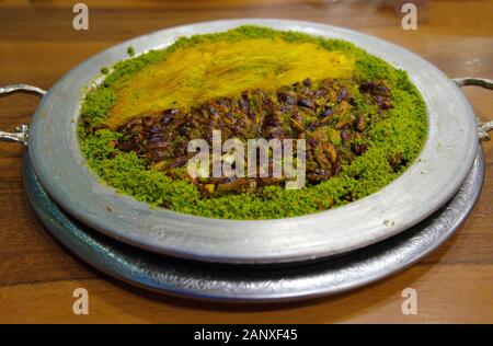 Tradizionale dessert turco kunefe, kunafa, kadayif con polvere di pistacchi e formaggio hot mangiato un dolce. Gaziantep il famoso croccante di 'kunefe' Foto Stock