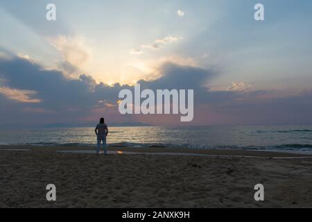 "Kuşadası-Güzelçamlı' / Turchia sulla spiaggia per guardare il sole che tramonta donna Foto Stock