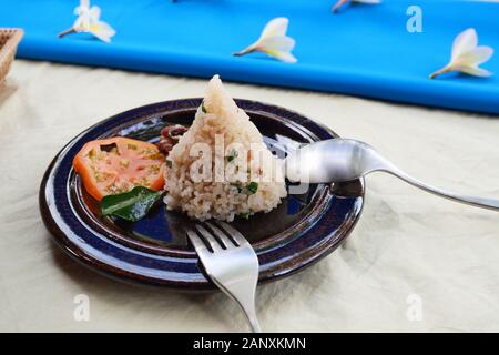 Zongzi o cinese tradizionale di riso appiccicoso gnocco con fette di pomodoro con cucchiaio e forchetta sul piatto, cucina cinese sul tavolo ricoperto in bianco e blu Foto Stock