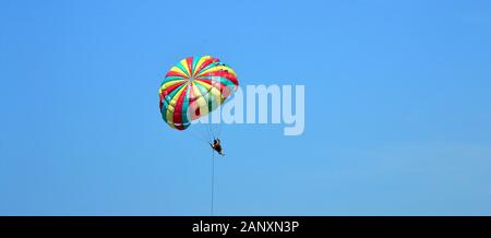 Il parasailing a Patong Beach, Phuket, Thailandia, in Asia, in una giornata calda con un cielo blu Foto Stock