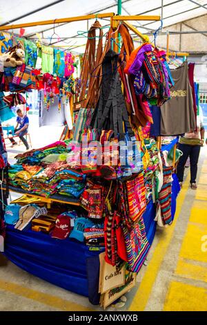 Puerto Limon Costa Rica - 8 Dicembre 2019: etnico souvenir, berretti da baseball, sacchetti con vari pattern appesi in strada del mercato Foto Stock