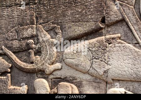 Parete carving bassorilievo con animali - coccodrillo catturato un pesce piccolo, grande pesce, Prasat tempio Bayon, nel famoso Angkor Wat complessa, culto khmer Foto Stock