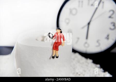 Foto astratte concetto di seduta con un telefono sulla tazza di gabinetto. Foto Stock