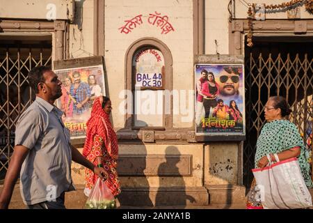 Due donne e un uomo che passa il Palace Talkies, un cinema a Byculla, Mumbai, India, poster di una lingua Bhojpuri esposto dalla biglietteria Foto Stock