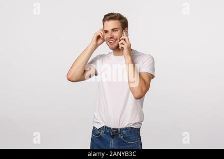Entusiasta e curioso, spensierata bionda sorridente ragazzo Caucasico presentano una interessante conversazione, hai chiamata dal dipendente, ricevere la buona novella, tenendo Foto Stock