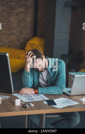 Premuto giovane uomo stanco dal suo lavoro Foto Stock