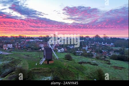 Il sole sorge sopra il villaggio di Brill vicino a Aylesbury nel Buckinghamshire. Il Grade II* elencati Windmill risale al xvii secolo. Foto Stock