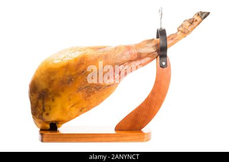 Tutto il prosciutto iberico gamba spagnolo in un prosciutto in legno stand isolato su sfondo bianco Foto Stock