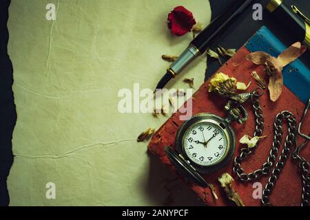 Vintage orologio da tasca e a penna in ottone sul vecchio libro. Alle ore 8 di mattina. Vista superiore e spazio di copia. Istruzione e stile vintage concetto. Foto Stock