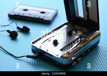 Inquadratura ad angolo elevato di un lettore di cassette e di una cassetta su una superficie blu Foto Stock