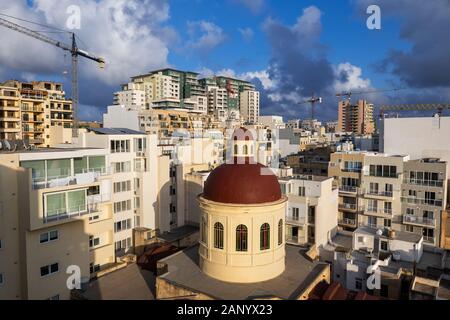 Città di Sliema a Malta, townscape con edifici di appartamenti, condomini e cupola della chiesa parrocchiale di Gesù di Nazaret. Foto Stock