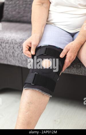 Persona che mette in ginocchio protettivo rinforzo supporto ginocchio Foto Stock