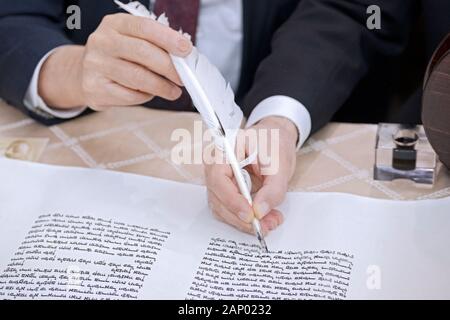 Il completamento della scrittura di una nuova Torah è un processo comune dove congregants, assistito da un graffietto, compilare una lettera. In Bayside, Queens, NYC. Foto Stock