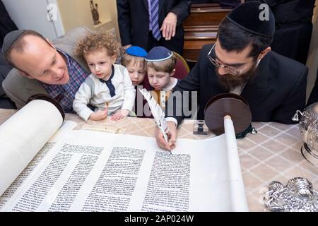 Il completamento della scrittura di una nuova Torah è un processo comune dove congregants, assistito da un graffietto, compilare una lettera. In Bayside, Queens, NYC. Foto Stock