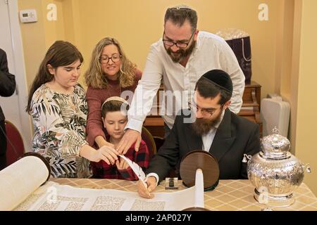 Il completamento della scrittura di una nuova Torah è un processo comune dove congregants, assistito da un graffietto, compilare una lettera. In Bayside, Queens, NYC. Foto Stock