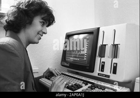 Anni ottanta, storico, una signora lavorando a un computer dell'epoca, un NEC APC personal computer un affidabile computer aziendali. Introdotto nel 1983, che si correva su MS-DOS, da 8" dischi floppy e fu usato in molte aziende e istituzioni finanziarie del giorno in ufficio per scopi di somministrazione. Foto Stock