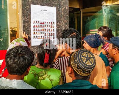 Uigurs alla ricerca dei loro familiari mancati nella vecchia parte distrutta dell'Oasi Kashgar dopo i tumulti nel luglio 2009 Foto Stock