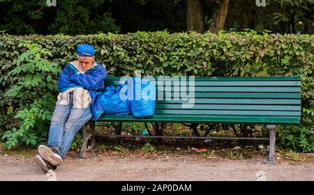 Senzatetto dormire su una panchina nel parco di Praga nella Repubblica Ceca. Foto Stock