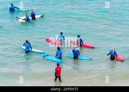 I surfisti principianti a partire una lezione di surf in spiaggia Great Western in Newquay in Cornovaglia. Foto Stock