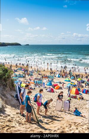 I turisti su un soleggiato Fistral Beach in Newquay in Cornovaglia. Foto Stock