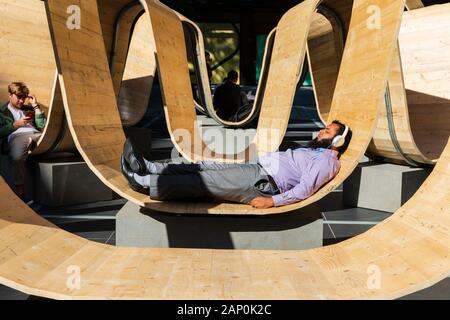 Ai visitatori di rilassarsi sulla si prega di essere seduto installazione presso il London Design Festival 2019 a Finsbury Avenue Square. Foto Stock